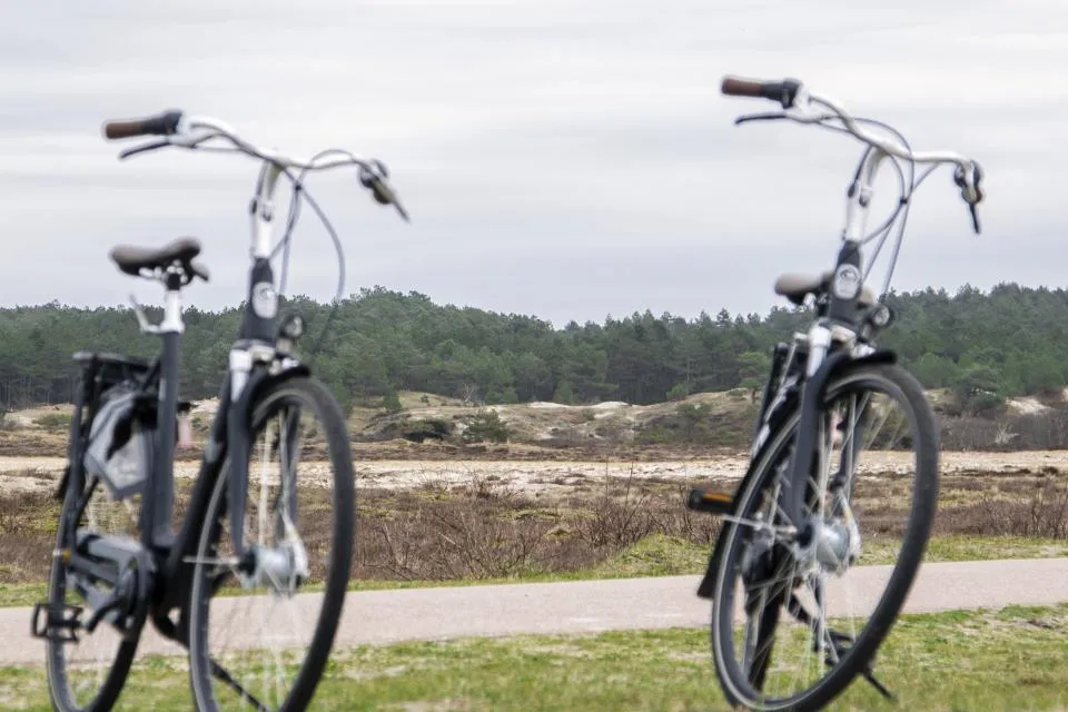 Twee fietsen langs het pad met het duinlandschap op de achtergrond